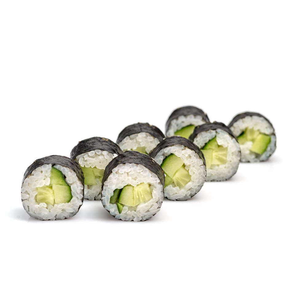 Eight cucumber maki sushi rolls, wrapped in nori and rice, arranged diagonally on a white background.